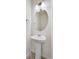 Compact powder room features a pedestal sink, an oval mirror, and a classic design at 17949 Dandy Brush Ln, Parker, CO 80134