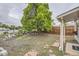 A spacious backyard featuring a large tree, rock wall, and wooden fence at 1680 Simms St, Lakewood, CO 80215