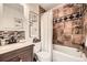 Cozy bathroom features tile accents, a vanity with storage, and a shower and tub combination with a white shower curtain at 1680 Simms St, Lakewood, CO 80215