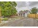 Charming front yard with vibrant red door, wooden fence, and mature tree at 1680 Simms St, Lakewood, CO 80215