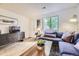 Bright living room featuring wood floors, a blue sofa, and stylish decor at 1680 Simms St, Lakewood, CO 80215