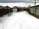 Snowy backyard with a fence and storage shed at 645 S Perry St, Denver, CO 80219