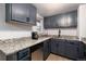 Well-lit kitchen featuring granite countertops, stainless steel appliances, and updated cabinetry at 6903 W 52Nd Pl, Arvada, CO 80002