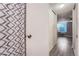 Hallway view leading to a neutral bedroom and bathroom with patterned shower curtain at 2231 S Vaughn Way # 114B, Aurora, CO 80014