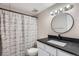 Bathroom featuring updated vanity, modern fixtures, round mirror, and a shower-tub combo at 2231 S Vaughn Way # 114B, Aurora, CO 80014