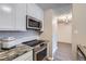 Modern kitchen features stainless steel appliances, granite countertops and white cabinetry at 2231 S Vaughn Way # 114B, Aurora, CO 80014