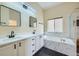 Elegant bathroom featuring double vanity, soaking tub, and stylish finishes at 6596 Silverleaf Ave, Firestone, CO 80504