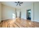 Spacious main bedroom with hardwood floors, ceiling fan, and open doors leading to the bathroom at 6596 Silverleaf Ave, Firestone, CO 80504