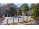 Community pool with stone pillars, a fence and a covered pergola, surrounded by mature trees at 2575 S Syracuse Way # M206, Denver, CO 80231