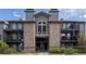 Apartment building featuring stone accents, gray siding, and balconies with outdoor seating at 2575 S Syracuse Way # M206, Denver, CO 80231