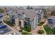 Aerial view of condo with stone and gray siding, surrounded by landscaping and parking at 2575 S Syracuse Way # M206, Denver, CO 80231