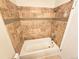 Bathroom featuring tiled walls and a shower head with a white bathtub at 1125 S Oneida St # F, Denver, CO 80224