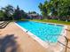 Sparkling community pool surrounded by lush landscaping and bathed in sunlight on a clear, blue-sky day at 1125 S Oneida St # F, Denver, CO 80224