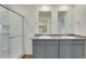 Modern bathroom featuring dual sinks, granite countertops, and a glass-enclosed shower at 1639 Pinnacle Ave, Lochbuie, CO 80603