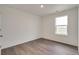 Bedroom features light wood-look floors, a window, and painted white walls at 1639 Pinnacle Ave, Lochbuie, CO 80603