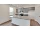 Modern kitchen with a gray cabinets, stone countertops, and a large center island with a sink at 1639 Pinnacle Ave, Lochbuie, CO 80603