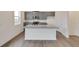 Modern kitchen with stone countertops, gray cabinets, stainless appliances and large center island at 1639 Pinnacle Ave, Lochbuie, CO 80603