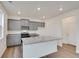 Modern kitchen with gray cabinets, stainless appliances, stone countertops and a large center island at 1639 Pinnacle Ave, Lochbuie, CO 80603