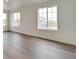Bright living room with large windows offering neighborhood views and modern flooring at 1639 Pinnacle Ave, Lochbuie, CO 80603