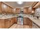 Updated kitchen featuring wood cabinets and tile backsplash at 13500 E Cornell Ave # 309, Aurora, CO 80014