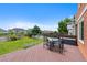 Outdoor patio featuring a table and chairs, overlooking the grassy backyard, mature trees, and vibrant flowers at 11366 Haswell Dr, Parker, CO 80134