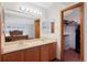 Bathroom features double sinks and vanity leading into bedroom and walk in closet at 11366 Haswell Dr, Parker, CO 80134