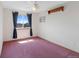 Cozy bedroom with pink carpet, ceiling fan, and a window providing a view of the neighborhood at 11366 Haswell Dr, Parker, CO 80134