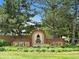 Charming Clarke Farms neighborhood sign, framed by mature trees, manicured landscaping, and beautiful entrance at 11366 Haswell Dr, Parker, CO 80134