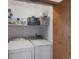 Functional laundry room with modern washer and dryer units, ample storage shelving, and convenient access at 11366 Haswell Dr, Parker, CO 80134
