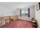 Bright loft area featuring pink carpet, a large window, and wooden railing overlooking the floor below at 11366 Haswell Dr, Parker, CO 80134