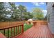 Fenced backyard with a stained deck, green grass, and mature trees at 9522 Castle Ridge Cir, Highlands Ranch, CO 80129