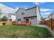Backyard featuring a well-maintained lawn, wooden fence, deck, and home exterior with multiple windows at 9522 Castle Ridge Cir, Highlands Ranch, CO 80129
