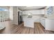 Open-concept kitchen with stainless steel appliances, white cabinets, and wood flooring at 9522 Castle Ridge Cir, Highlands Ranch, CO 80129