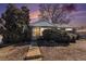 Charming single-story brick home with mature trees at dusk at 7232 Kalamath St, Denver, CO 80221