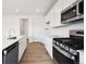 Well-lit kitchen with stainless steel appliances, white cabinets, and durable wood-look flooring at 24737 E 40Th Ave, Aurora, CO 80019