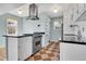 Stylish kitchen featuring stainless steel appliances, a modern vent hood, and ample counter space at 1209 Locust St, Denver, CO 80220