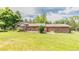 Expansive brick home backyard with a covered patio, mature trees, and well-maintained lawn at 13990 Berry Rd, Golden, CO 80401