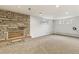 Carpeted basement with unique brick fireplace and natural light from windows at 13990 Berry Rd, Golden, CO 80401