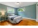 Bright bedroom with hardwood floors, light blue walls, and natural light at 13990 Berry Rd, Golden, CO 80401