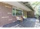Relaxing covered porch with chairs, a small table, and a brick facade with large windows at 13990 Berry Rd, Golden, CO 80401