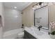Nicely updated bathroom with white and wood tiling, and a well lit vanity mirror at 1670 S Quieto Ct, Denver, CO 80223