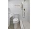 Modern bathroom featuring sleek white tiling, brass fixtures, and a walk-in shower at 1670 S Quieto Ct, Denver, CO 80223