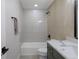 Modern bathroom featuring a shower-tub combo, gray tiling, and a vanity with a sink at 1670 S Quieto Ct, Denver, CO 80223