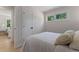 Bright bedroom with neutral decor, featuring hardwood floors, white walls, and large window at 1670 S Quieto Ct, Denver, CO 80223