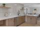 Well-lit kitchen showcasing quartz countertops, stainless steel dishwasher and modern fixtures at 1670 S Quieto Ct, Denver, CO 80223