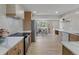 Modern kitchen with stainless steel appliances, quartz countertops, and an open layout into the living area at 1670 S Quieto Ct, Denver, CO 80223