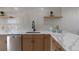 Well-lit kitchen showcasing quartz countertops, stainless steel dishwasher and modern fixtures at 1670 S Quieto Ct, Denver, CO 80223