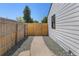 Charming side yard with a wooden fence and gate, complemented by gravel landscaping, providing a clean and private outdoor space at 1670 S Quieto Ct, Denver, CO 80223
