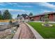 Expansive backyard boasts a covered patio, lush artificial turf, and brick-lined walkway for elegant outdoor living at 2140 S Youngfield St, Lakewood, CO 80228
