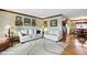 Bright living room with hardwood floors, white couches, and views into the dining room at 2140 S Youngfield St, Lakewood, CO 80228
